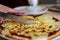 Woman cuts by slices homemade vegetarian pizza with tomatoes and mozzarella cheese