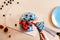 Woman cutting cake with colourful cream. Juicy filling with red berries