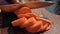 Woman cutting carrot on table, close-up. Hands cutting carrots on a cutting board. Young woman cutting vegetables in the