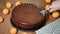 A woman is cutting a chocolate Sacher cake.