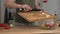 Woman cutting feta cheese for greek salad at home kitchen