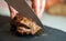 Woman cutting fried duck fillet