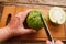 Woman cutting jackfruit on wooden board top view