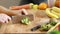 Woman cutting kiwi on pieces