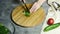 Woman cutting leek with knife on a wooden board