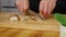 Woman cutting mushrooms on chopping wooden board