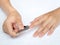 Woman cutting nails using nail clipper on white background. heal