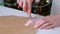 Woman is cutting parts for gingerbread house from dough at home, hands closeup.