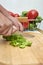 Woman cutting peppers Gazpacho, Andalusian and some ingredient to prepare it, such as tomato, garlic and onion, cucumber, on a