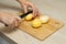 woman cutting potatoes on a kitchen board.