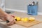 woman cutting potatoes on a kitchen board.