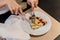 Woman is cutting Puccia Al Tarfuto by knife: Thin crispy dough filled with mascarpone, stracciatella, parmesan and black truffle
