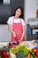 Woman cutting purple cabbage on board in kitchen room