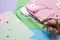 Woman cutting ribbon with beautiful scissors near colorful paper sheets, closeup