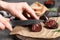 Woman cutting tasty blood sausage at grey table, closeup