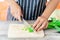 Woman cutting water spinach on wooden cutting board