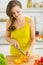 Woman cutting yellow bell pepper on cutting board