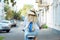 Woman is cycling in blue dress on bicycle on empty city street