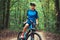 Woman cyclist rides mountain bike forest trails