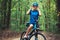 Woman cyclist rides mountain bike forest trails