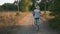 Woman cyclist rides retro old bicycle in park green area. Happy smiling girl is cycling on vintage bike on country road with bouqu