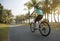 woman cyclist riding bike in tropical spring park