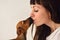 Woman with dachshund dog studio portrait kissing