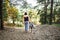 Woman and Dalmatian dog walking and looking away in forest