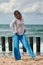 Woman dancer in ethnic blue and white clothes dancing on beach, outdoor dancing performance