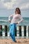 Woman dancer in ethnic blue and white clothes dancing on beach, outdoor dancing performance