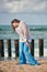 Woman dancer in ethnic blue and white clothes dancing on beach, outdoor dancing performance