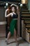 Woman dancer in green skirt posing in home interior