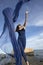 Woman dancing with blue fabric on the beach in Connecticut.