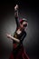 Woman dancing flamenco with castanets on black