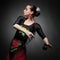 Woman dancing flamenco with castanets on black