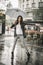 Woman dancing in the rain with umbrella, Splash in puddle