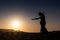 Woman dancing to the famous Arab belly dance. With sunset in the arid desert plain of Namibe. Africa. Angola