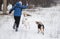 Woman dancing with two mixed-breed dogs in winter park