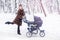 Woman dancing while winter walk with a stroller.