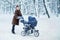 Woman dancing while winter walk with a stroller.