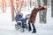 Woman dancing while winter walk with a stroller