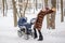 Woman dancing while winter walk with a stroller