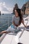 Woman with dark hair in casual clothes relaxing on yacht in open