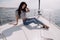 Woman with dark hair in casual clothes relaxing on yacht in open