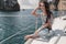 Woman with dark hair in casual clothes relaxing on yacht in open