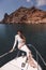 woman with dark hair in luxurious white dress relaxing on the deck of yacht, sailing in mediterranean sea