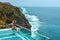 Woman with dark hair relaxing in transparent swimming pool with fantastic ocean view