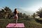 Woman with dark hair in sportive suit making yoga on sunrise with volcano Agung view