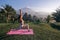 Woman with dark hair in sportive suit making yoga on sunrise with volcano Agung view