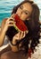 woman with dark hair in swimsuit eating watermelon